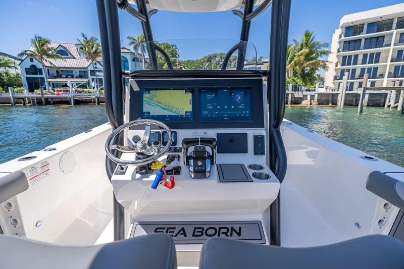 Slide: The Image of 2026 Sea Born LX27 Center Console boat dashboard with dual screens and steering wheel. - 58