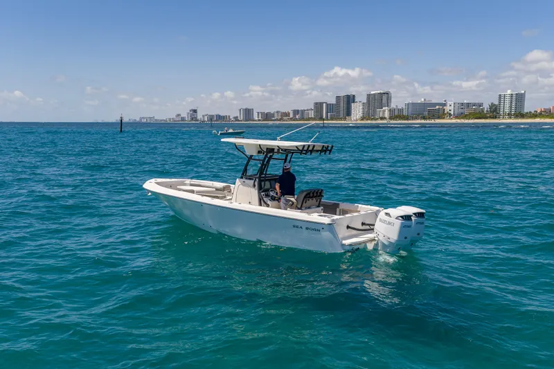 Slide: The Image of 2026 Sea Born LX27 Center Console boat cruising on blue ocean near city skyline. - 6