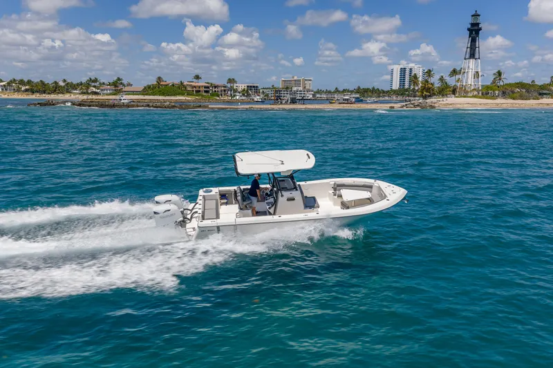 Slide: The Image of 2026 Sea Born LX27 Center Console boat cruising near a coastal lighthouse. - 8