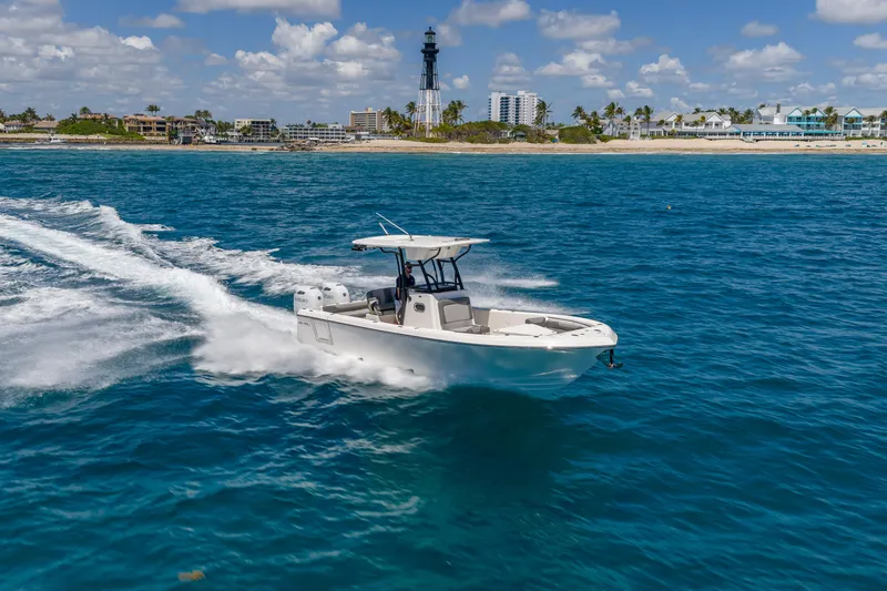Slide: The Image of 2026 Sea Born LX27 Center Console cruising on blue ocean near coastline. - 9