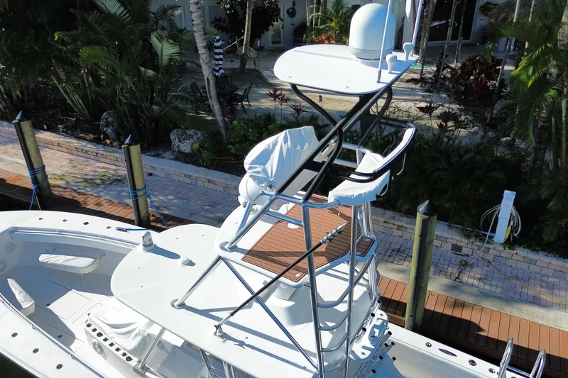 Slide: The Image of 2014 SeaHunter 45 Tournament boat with elevated helm station, docked near lush greenery. - 19