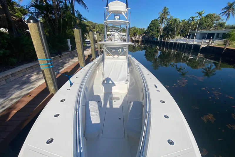 Slide: The Image of 2014 SeaHunter 45 Tournament boat docked by a tropical canal with palm trees. - 26