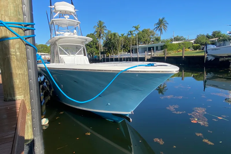 Slide: The Image of 2014 SeaHunter 45 Tournament boat docked, blue hull, clear sky, palm trees in background. - 32