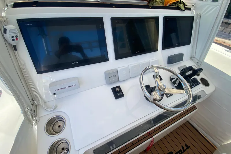 Slide: The Image of Control panel of a 2014 SeaHunter 45 Tournament boat with multiple screens and steering wheel. - 39