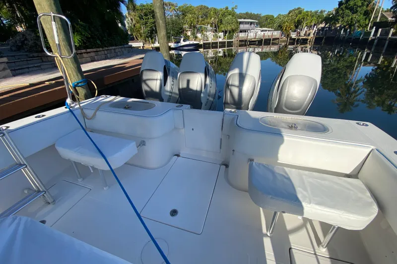 Slide: The Image of 2014 SeaHunter 45 Tournament boat with four powerful outboard engines docked by a serene waterfront. - 42