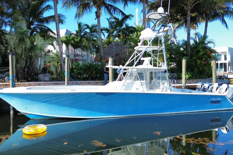 Slide: The Image of Blue 2014 SeaHunter 45 Tournament boat docked by palm trees. - 6
