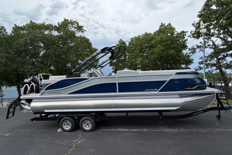 The Image of 2026 Harris Grand Mariner 250 CWDH pontoon boat on trailer, parked outdoors. - 1