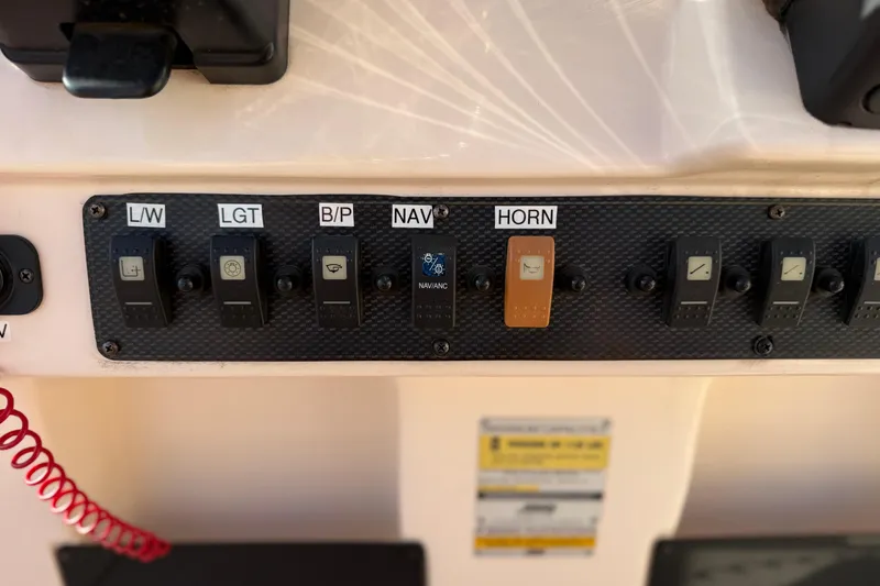 Slide: The Image of Control panel of a 2007 Grady-White Escape 209 boat with labeled switches. - 22