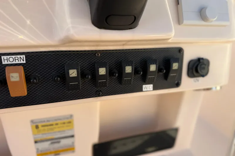 Slide: The Image of Control panel of a 2007 Grady-White Escape 209 boat with labeled switches. - 23