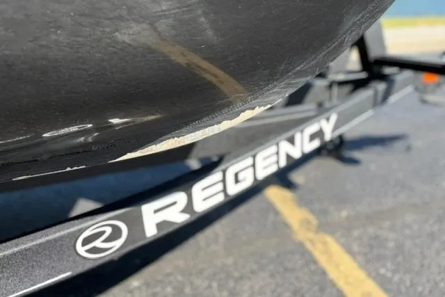 Slide: The Image of 2025 Regency 250 DL3 boat trailer with visible scratch on hull. - 16