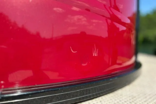 Slide: The Image of Close-up of a red 2025 Regency 250 DL3 boat with visible scratches. - 18