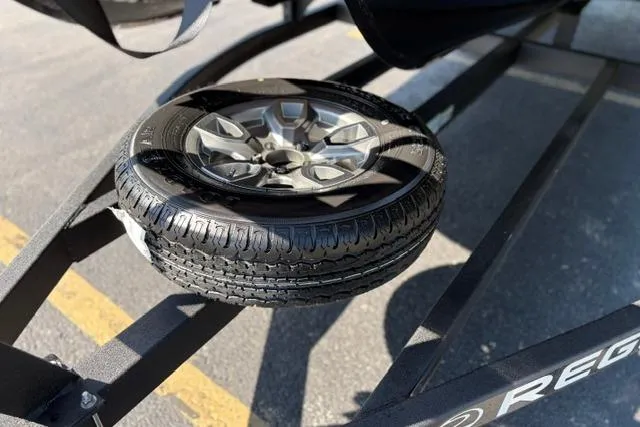 Slide: The Image of Spare tire on a 2025 Regency 250 DL3 trailer in a parking lot. - 21
