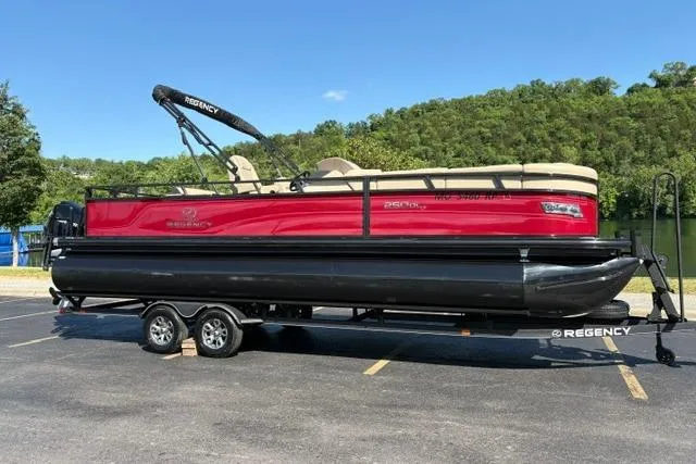 Slide: The Image of 2025 Regency 250 DL3 pontoon boat on trailer, parked outdoors. - 3