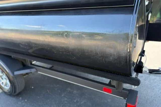 Slide: The Image of 2025 Regency 250 DL3 pontoon boat on trailer, close-up view of black hull. - 30