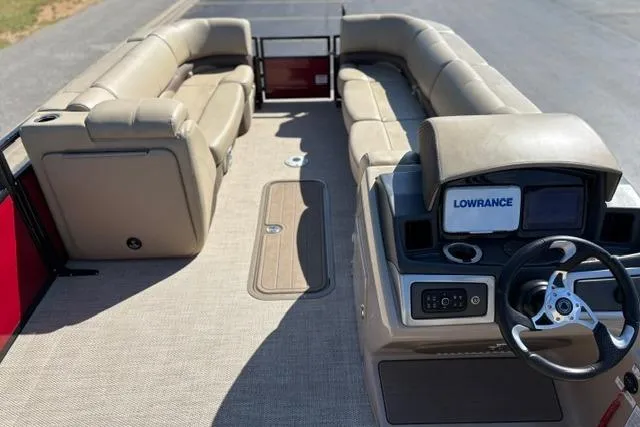 Slide: The Image of 2025 Regency 250 DL3 pontoon boat interior with beige seating and steering console. - 35