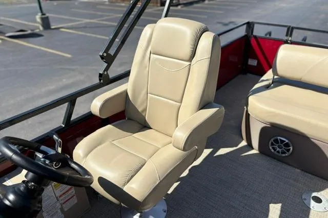 Slide: The Image of Captain's chair on 2025 Regency 250 DL3 pontoon boat, beige upholstery, steering wheel visible. - 37