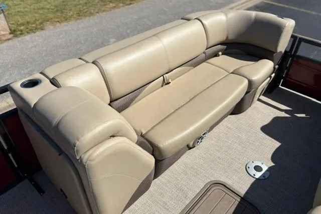 Slide: The Image of Luxurious beige seating on 2025 Regency 250 DL3 pontoon boat, featuring cup holder and storage. - 38