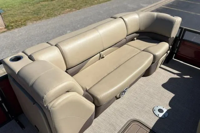 Slide: The Image of Beige seating on 2025 Regency 250 DL3 pontoon boat, featuring cup holder and carpeted flooring. - 39