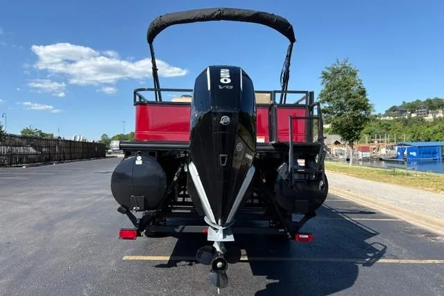 Slide: The Image of 2025 Regency 250 DL3 pontoon boat with powerful outboard motor, parked on sunny day. - 41