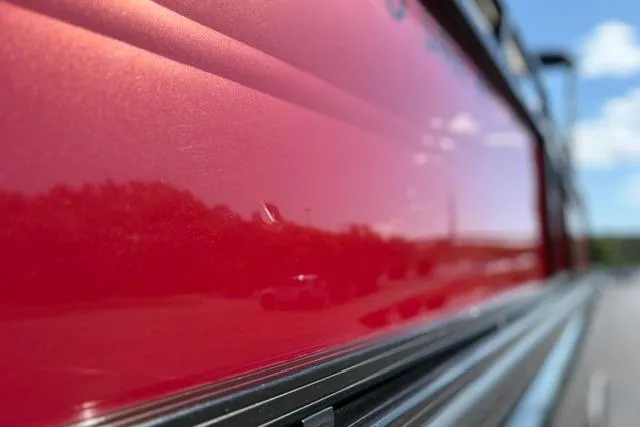 Slide: The Image of Close-up of shiny red exterior on 2025 Regency 250 DL3 boat. - 43