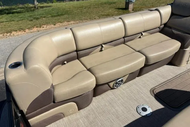Slide: The Image of Luxurious seating on 2025 Regency 250 DL3 pontoon boat, featuring beige upholstery and cup holder. - 45