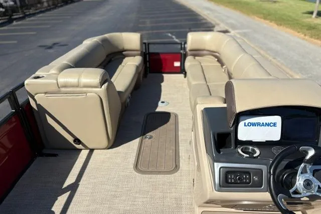 Slide: The Image of 2025 Regency 250 DL3 pontoon boat interior with beige seating and Lowrance navigation system. - 49