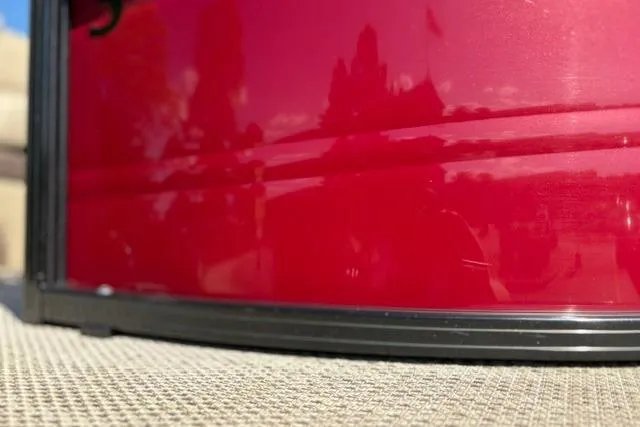 Slide: The Image of Close-up of a red 2025 Regency 250 DL3 boat exterior with reflections. - 53