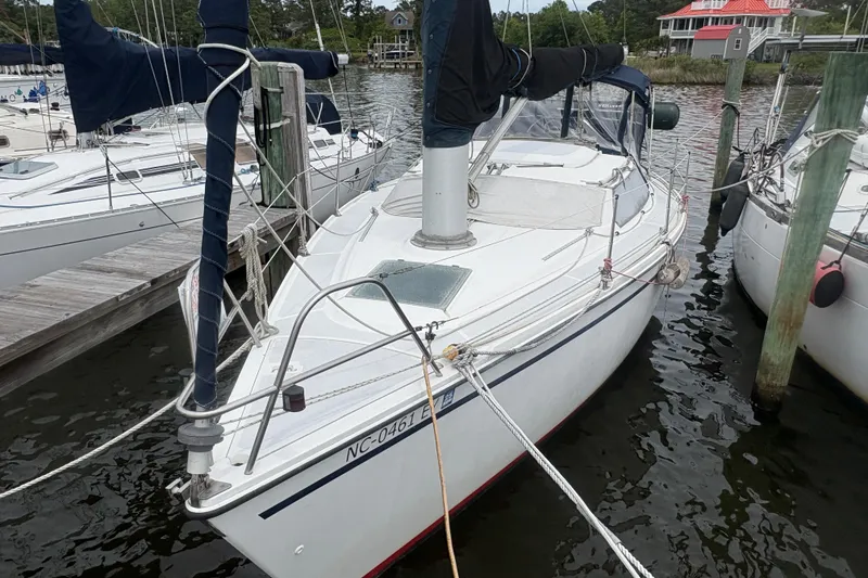 Slide: The Image of 1989 Hunter Vision 32 sailboat docked at a marina, featuring a sleek white hull. - 1