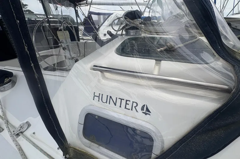 Slide: The Image of 1989 Hunter Vision 32 sailboat cockpit with steering wheel and protective cover. - 16