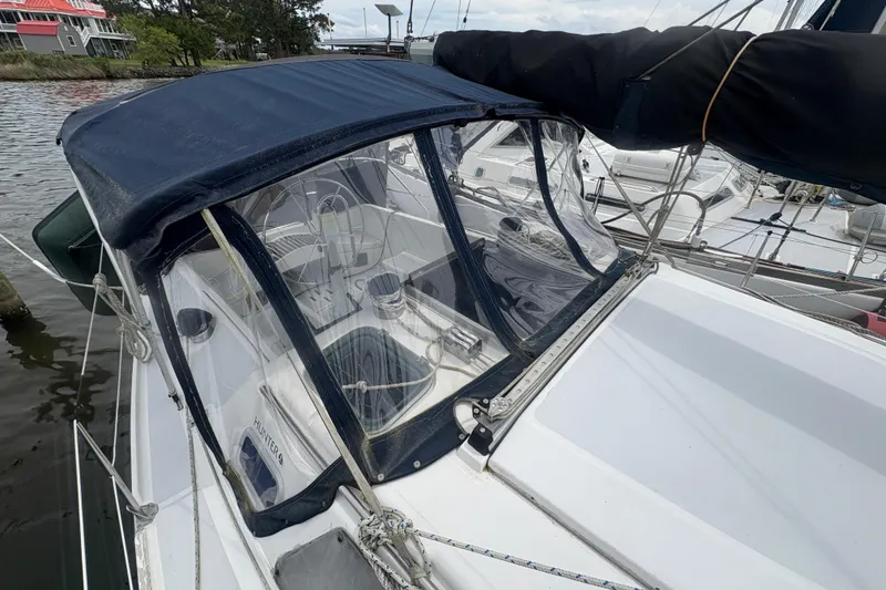 Slide: The Image of 1989 Hunter Vision 32 sailboat with blue canopy docked at marina. - 17