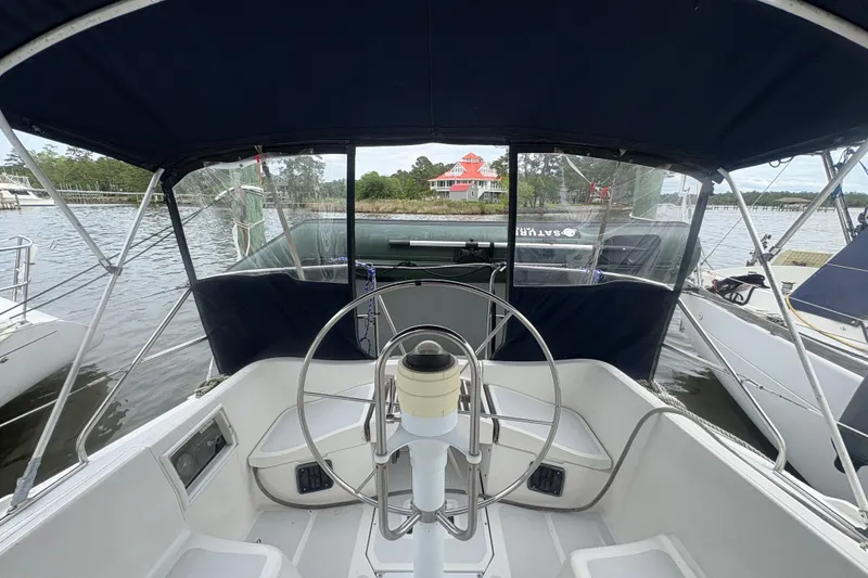 Slide: The Image of Cockpit view of 1989 Hunter Vision 32 sailboat docked by a scenic waterfront. - 23