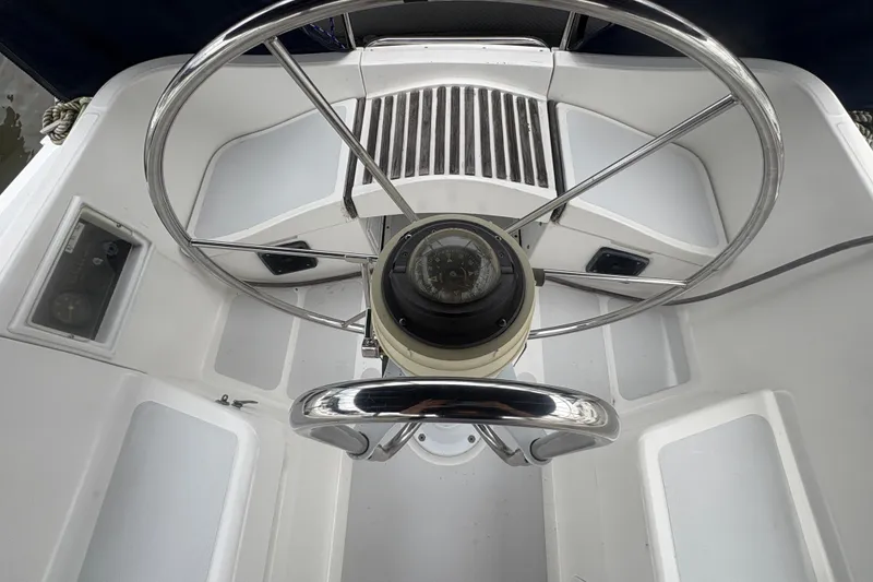 Slide: The Image of Steering wheel and compass of a 1989 Hunter Vision 32 sailboat cockpit. - 24