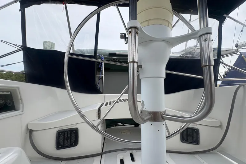 Slide: The Image of Cockpit of 1989 Hunter Vision 32 sailboat with large steering wheel and seating area. - 27