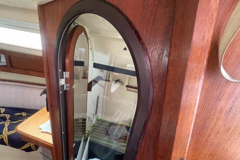 Slide: The Image of Interior of 1989 Hunter Vision 32 sailboat with wooden cabinetry and mirror. - 48