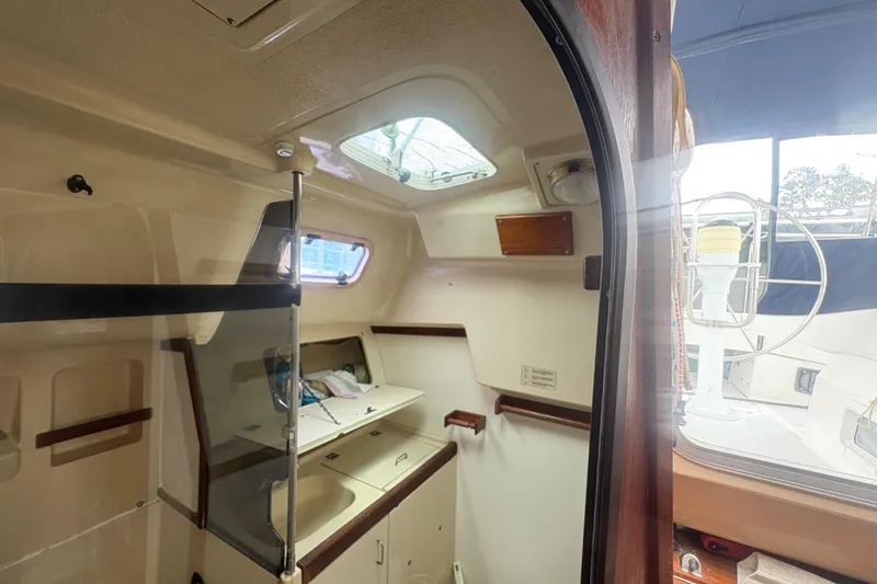 Slide: The Image of Interior of 1989 Hunter Vision 32 sailboat, featuring compact kitchen area with natural light. - 49