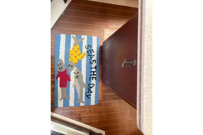 Slide: The Image of Colorful rug with sharks and "Seas the Day" text on a boat floor. - 53