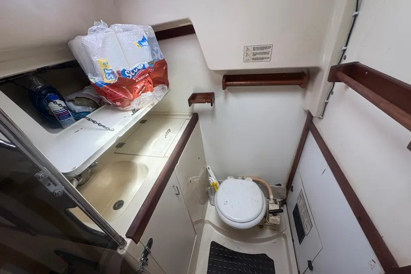 Slide: The Image of Compact bathroom in 1989 Hunter Vision 32 sailboat with toilet, sink, and storage shelves. - 54