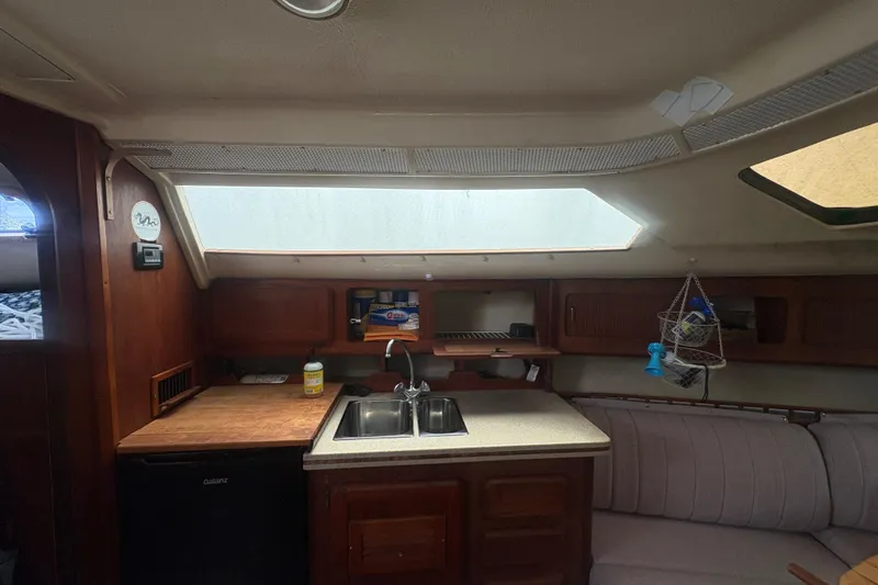 Slide: The Image of Interior of 1989 Hunter Vision 32 sailboat kitchen with sink, cabinets, and seating area. - 58