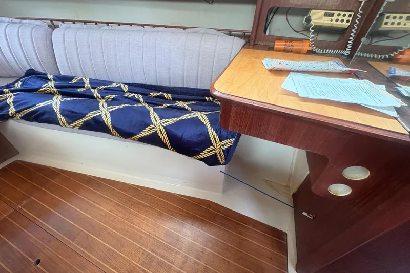 Slide: The Image of Interior of 1989 Hunter Vision 32 sailboat with wooden desk and cushioned seating. - 68