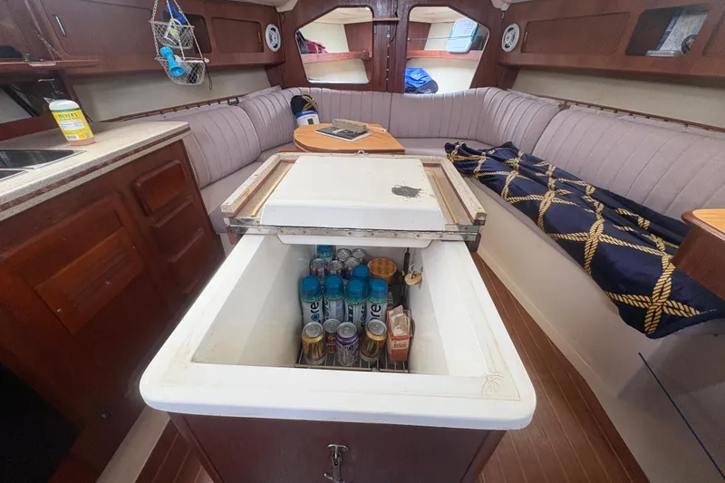 Slide: The Image of Interior of 1989 Hunter Vision 32 sailboat with open cooler and cozy seating area. - 69