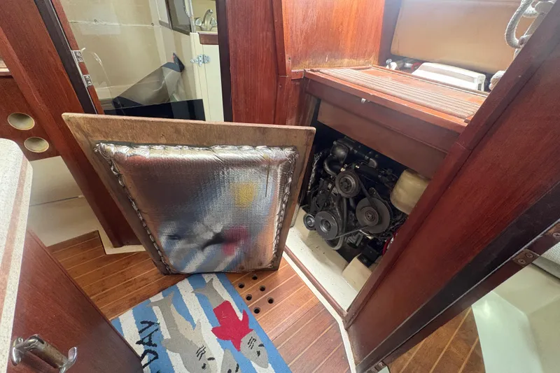 Slide: The Image of Engine compartment of a 1989 Hunter Vision 32 sailboat, showcasing interior woodwork and engine details. - 78