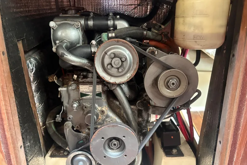 Slide: The Image of Engine compartment of a 1989 Hunter Vision 32 sailboat, showcasing mechanical components and belts. - 80