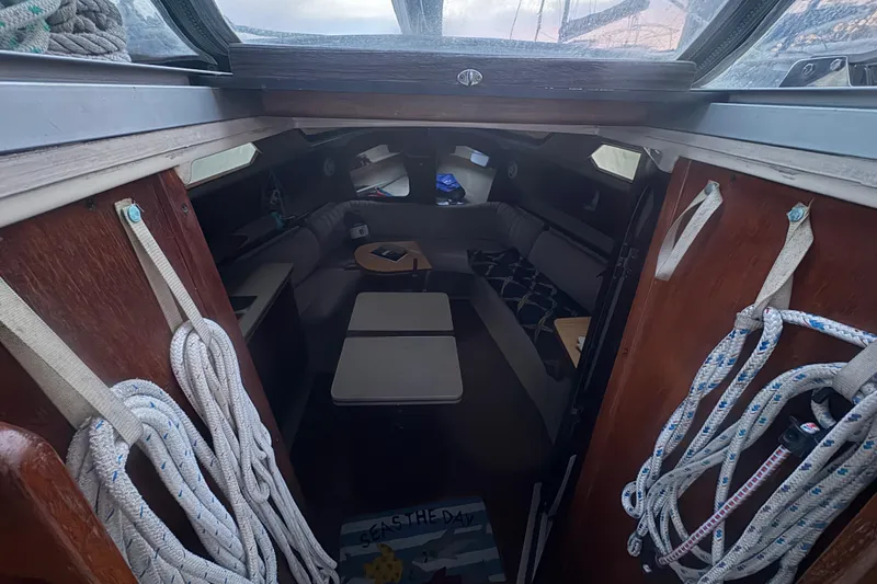 Slide: The Image of Interior of 1989 Hunter Vision 32 sailboat, featuring cozy seating and nautical decor. - 82