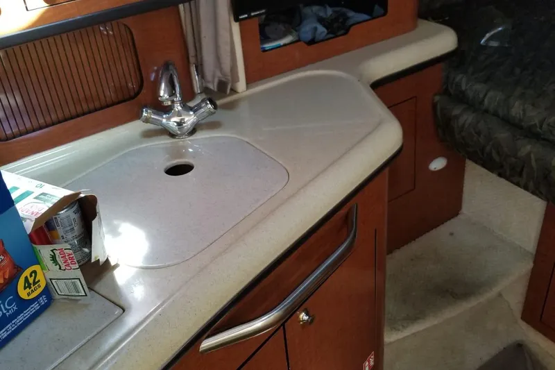 Slide: The Image of 2004 Sea Ray 300 Sundancer interior with kitchenette and sink. - 12