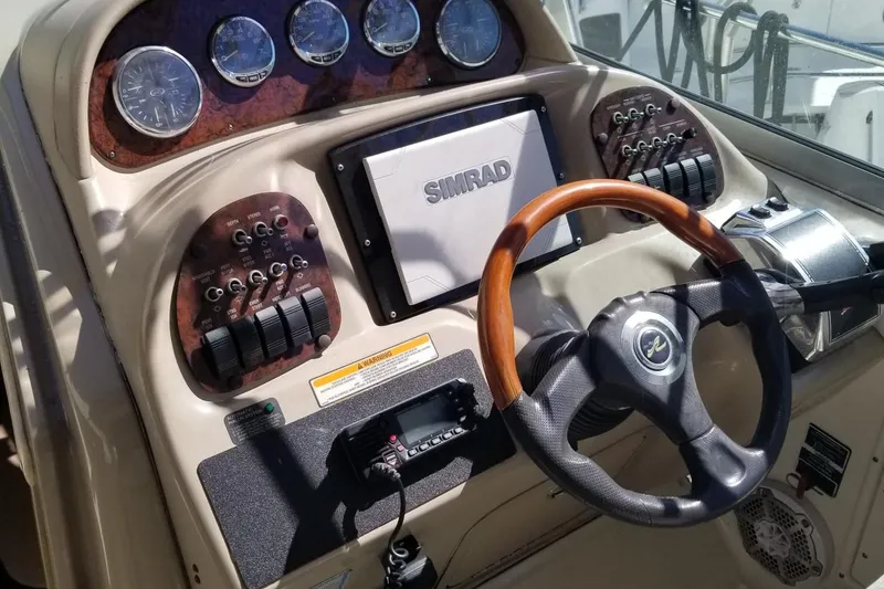 Slide: The Image of 2004 Sea Ray 300 Sundancer helm with Simrad display and wooden steering wheel. - 14