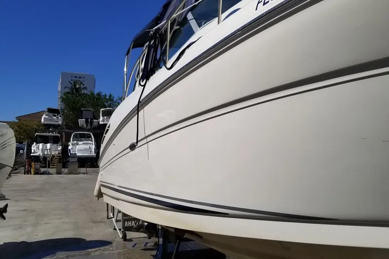 Slide: The Image of 2004 Sea Ray 300 Sundancer boat in a marina, surrounded by other vessels. - 16