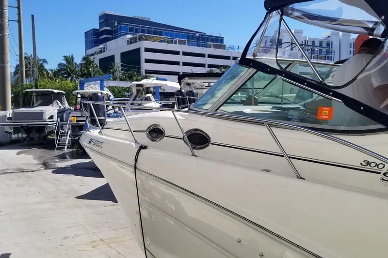 Slide: The Image of 2004 Sea Ray 300 Sundancer docked, with modern buildings in the background. - 21