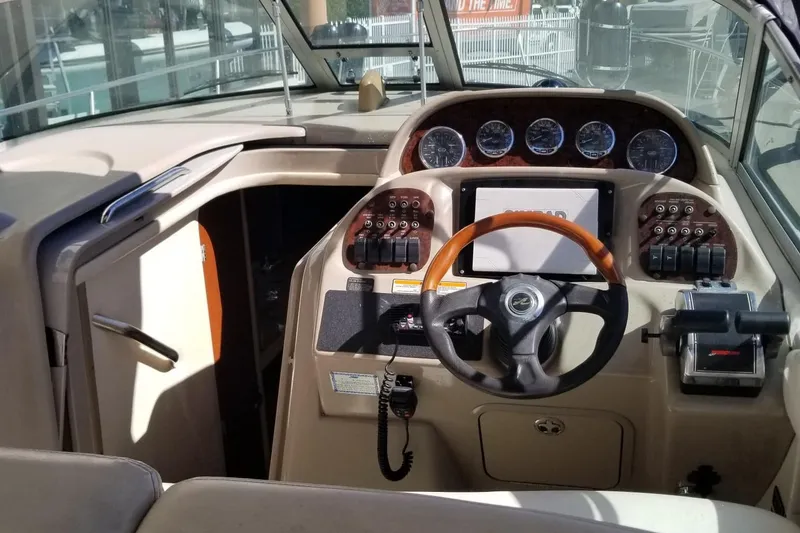 Slide: The Image of 2004 Sea Ray 300 Sundancer helm with gauges, steering wheel, and control panel. - 22