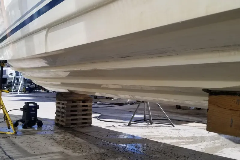 Slide: The Image of 2004 Sea Ray 300 Sundancer hull on dry dock, supported by blocks and stands. - 23