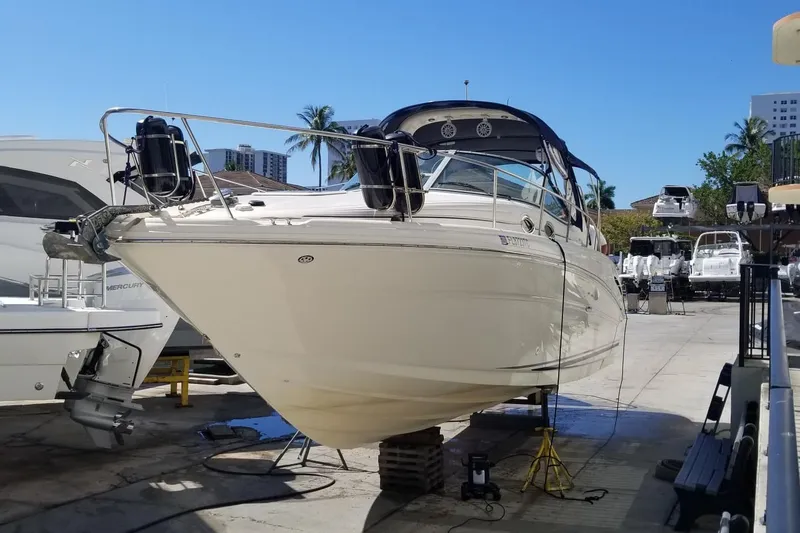 Slide: The Image of 2004 Sea Ray 300 Sundancer boat on dry dock, surrounded by other vessels. - 24